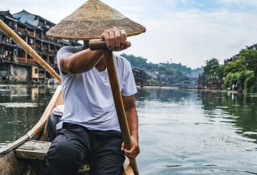 Traditional Chinese fisherman rowing a small boat